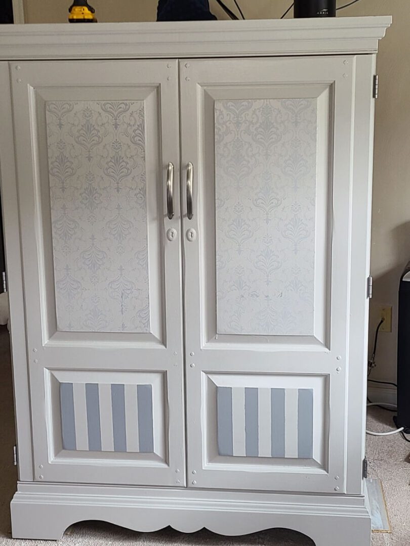 A white cabinet with two doors and a striped door.