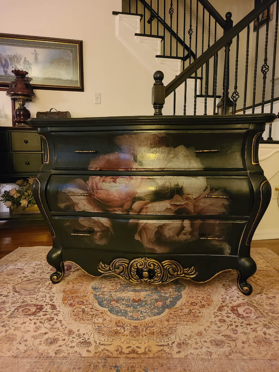 A black dresser with some paintings on it