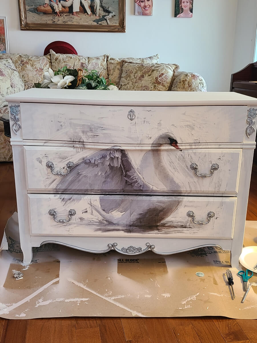 White chest of drawers with swan design.