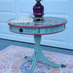 Painted table with purple lamp and rug.