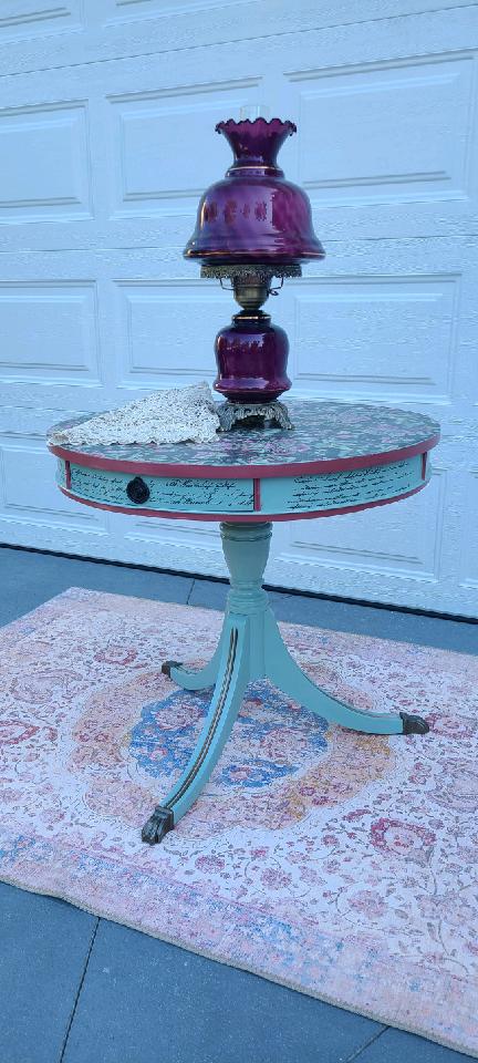 Painted table with purple lamp and rug.